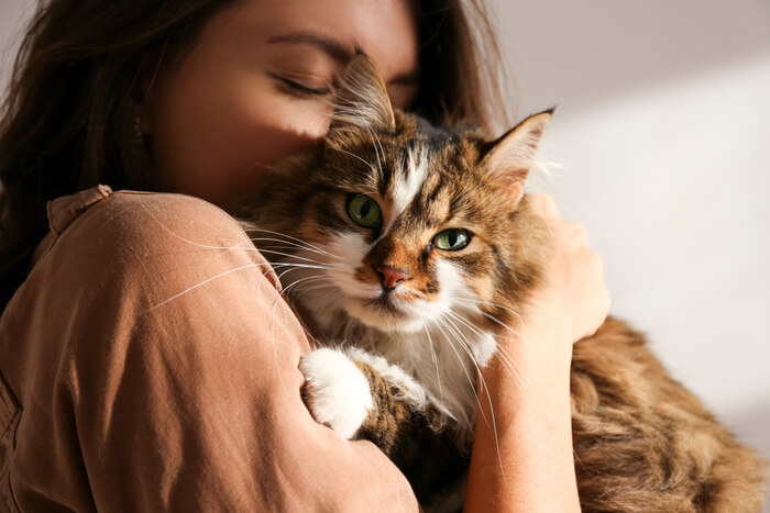 Donna che tiene e abbraccia teneramente il suo amato gatto