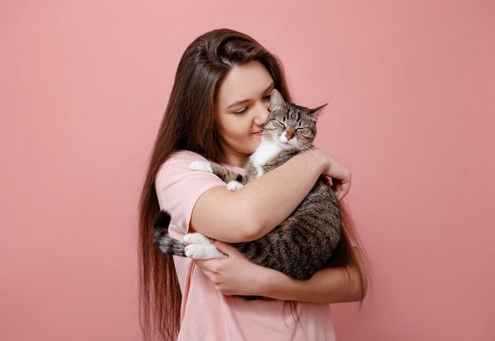 Un dolce momento immortalato da un gatto che abbraccia amorevolmente il suo padrone, dimostrandogli affetto e compagnia.