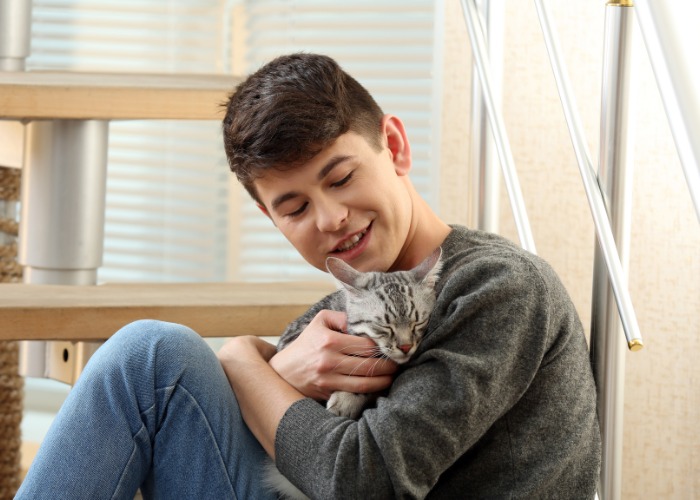 Immagine che cattura un momento commovente di un bambino che accarezza dolcemente un gatto.